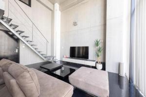 a living room with a couch and a tv at ARTK'SJosui in Fukuoka