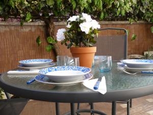 uma mesa com pratos azuis e brancos e um vaso com flores em Joe's Unforgettable Vatican Nest em Roma