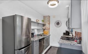 a large kitchen with a stainless steel refrigerator at Studio Apartment in Smithtown