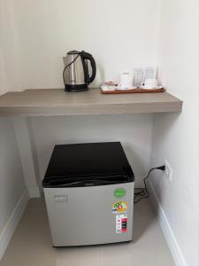 a microwave under a counter with a table on top at โรงแรม นีโอ รีสอร์ท in Ban Thap Nang