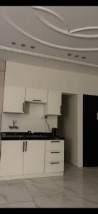 a kitchen with white cabinets and a white ceiling at استديو ب دخول ذاتي in Hail