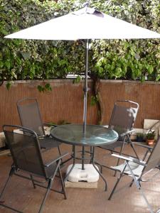 un tavolo con due sedie e un ombrellone di Joe's Unforgettable Vatican Nest a Roma
