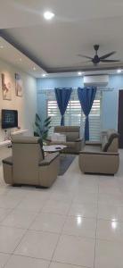 a living room with couches and a ceiling fan at Howie Home in Ipoh