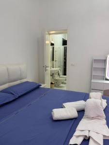 a bedroom with a blue bed with towels on it at Perla Azzurra in Savona