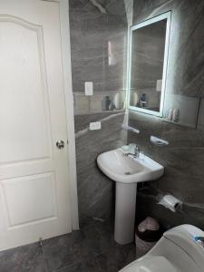 a bathroom with a sink and a mirror and a toilet at Departamento moderno con jacuzzi privado - Porto Vitoria in Tonsupa +6 photos