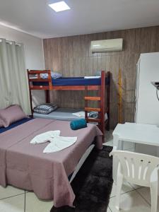 a bedroom with two bunk beds and a table at Pousada Dubai in Cuiabá