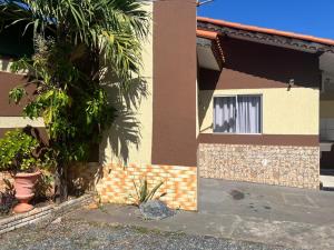 a house with a palm tree in front of it at Pousada Dubai in Cuiabá