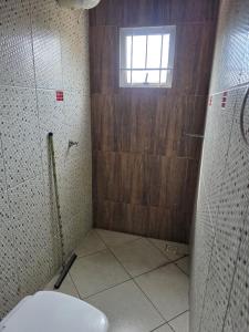 a bathroom with a toilet and a window at Pousada Dubai in Cuiabá
