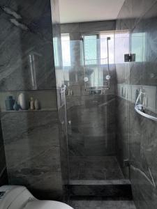 a bathroom with a glass shower with a toilet at Departamento moderno con jacuzzi privado - Porto Vitoria in Tonsupa
