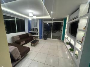 a living room with a couch and some windows at Departamento moderno con jacuzzi privado - Porto Vitoria in Tonsupa