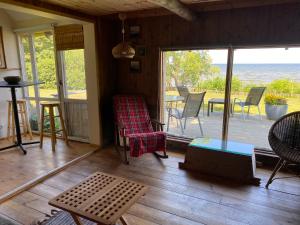 a room with a porch with chairs and a table at The Fishermans Net House in Bigauņciems
