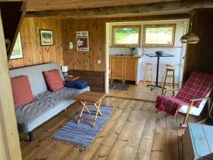 a living room with a couch and a table at The Fishermans Net House in Bigauņciems