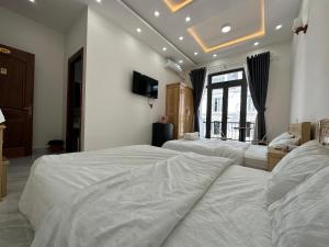 a bedroom with two beds and a tv on the wall at House 1994 in Xuan An