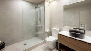 a bathroom with a shower and a toilet and a sink at Browns Boutique Hotel in Queenstown +36 photos