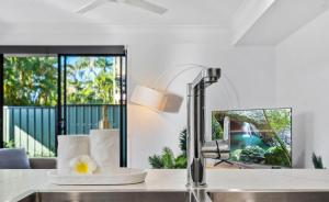 a kitchen counter with a sink and a mirror at Gemstone in Morayfield