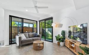 a living room with a couch and a flat screen tv at Gemstone in Morayfield +11 photos