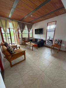 a large living room with a couch and chairs at Finca Agroturística La pradera in Acacías