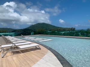 a pool with lounge chairs on the roof of a building at The Title Serenity Naiyang in Ban Bo Han