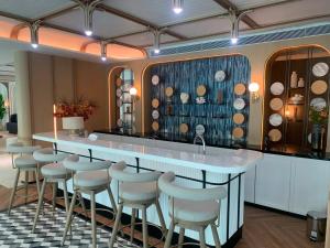 a bar with stools in a room with wine bottles at The Title Serenity Naiyang in Ban Bo Han