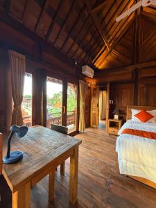 a bedroom with a bed and a wooden floor at Umah Nayoye Amed in Ambat