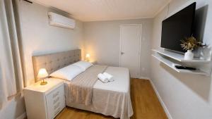 a small bedroom with a bed and a flat screen tv at Quarto Privativo Próximo à BR in São José
