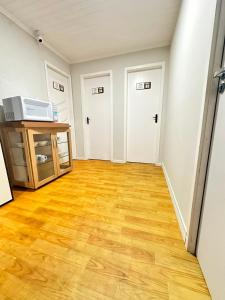 an empty living room with wooden floors and white walls at Quarto Privativo Próximo à BR in São José