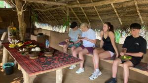a group of people sitting on a bench at Joy Land Resort in Habarana