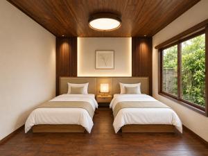 two beds in a room with two windows at LUX Niseko lodge in Niseko