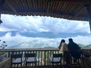 a man and a woman sitting on a balcony looking at the view at TIME Restaurant & Homestay Sa Pa in Sapa