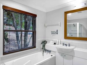 a white bathroom with a sink and a window at Vilamoura in Pokolbin +12 photos