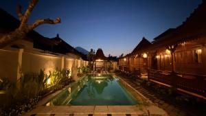 a pool in the courtyard of a house at night at Umah Nayoye Amed in Ambat