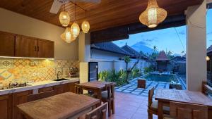an open kitchen with a pool in the background at Umah Nayoye Amed in Ambat