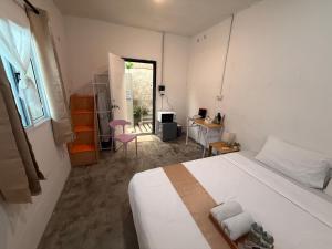 a bedroom with a large white bed and a desk at Bird Nest Hostel in Ko Tao