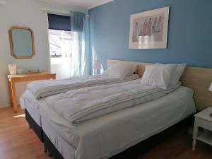 a large bed in a bedroom with a mirror at Hudiksvall Apartment Service # 4 in Hudiksvall +10 photos