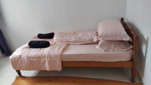 a bed with two pillows and a blanket on it at Cahaya 382 in Sitiawan