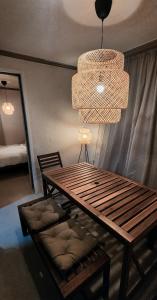 a wooden table with a bench and a chandelier at 낙원파크포도홈 in P'ungnyŏn-gol