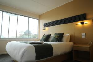 a bedroom with a large bed with a large window at Rayya Suites , Invercargill in Invercargill