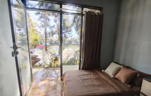 a bedroom with a bed and a large window at Hajeka Family 1 in Palayangan