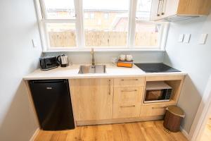 a small kitchen with a sink and a microwave at Rayya Suites , Invercargill in Invercargill