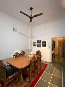 a dining room with a table and a ceiling fan at Ajay Niwas in Udaipur