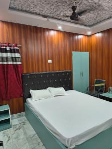 a bed in a room with a wooden wall at T & G Guest House in Patna