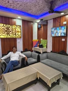 a man sitting in a chair in a room at T & G Guest House in Patna