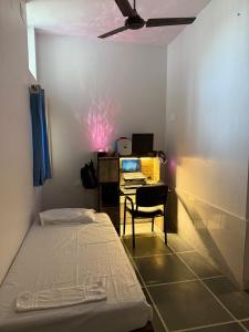 a bedroom with a bed and a desk with a computer at Ajay Niwas in Udaipur +4 photos