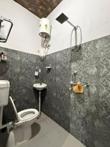 a bathroom with a toilet and a sink at Ajay Niwas in Udaipur