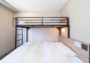 a bedroom with two bunk beds in a room at Super Hotel Higashi-Maizuru in Maizuru +92 photos
