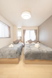 a bedroom with two beds and a window at BK Residence Kawasaki in Kawasaki