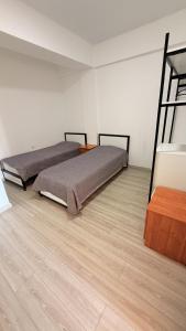 a bedroom with two beds and a wooden floor at Intour in Cholpon-Ata +16 photos