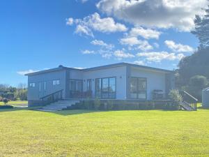 a large white house with a large yard at Springhill at The Beach in Karikari Peninsula