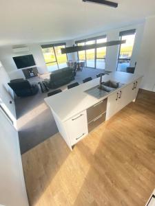 a kitchen with a sink and a living room at Springhill at The Beach in Karikari Peninsula