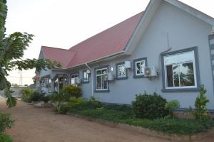 a blue house with a red roof at Nyerere Green Lodge in Kwangwazi